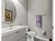 Powder room featuring a stylish white vanity, round mirror, and modern fixtures at 4910 Southern Valley Loop, Brooksville, FL 34601