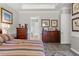 Spacious bedroom features decorative artwork and wooden dresser at 4910 Southern Valley Loop, Brooksville, FL 34601