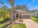 Charming single-Gathering home featuring a brick driveway, two-car garage, a cozy porch, and manicured landscaping at 4910 Southern Valley Loop, Brooksville, FL 34601