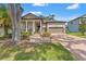 Charming single-Gathering home featuring a brick driveway, two-car garage, a cozy porch, and manicured landscaping at 4910 Southern Valley Loop, Brooksville, FL 34601