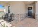 Inviting covered front porch with rocking chairs, stone accents, and brick flooring leading to the front door at 4910 Southern Valley Loop, Brooksville, FL 34601