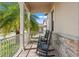 Inviting front porch with stone accents and black rocking chairs and beautiful landscaping at 4910 Southern Valley Loop, Brooksville, FL 34601