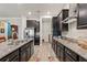 Sleek, modern kitchen with stainless steel appliances, granite countertops, and dark cabinetry at 4910 Southern Valley Loop, Brooksville, FL 34601