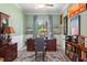 Bright office space featuring a large wooden desk, stylish decor, and serene outdoor views at 4910 Southern Valley Loop, Brooksville, FL 34601