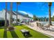 Community pool area with lush landscaping, cornhole game, outdoor seating, and a covered pool at 4910 Southern Valley Loop, Brooksville, FL 34601