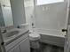 Bathroom has white tile walls around the bathtub and shower, and the floor has wood laminate at 5147 Larch Ln, New Port Richey, FL 34653
