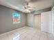 Bedroom with tile flooring, a ceiling fan, closet, and a window providing natural light at 5147 Larch Ln, New Port Richey, FL 34653