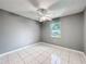 Bedroom with tile flooring, a ceiling fan, and a window providing natural light at 5147 Larch Ln, New Port Richey, FL 34653