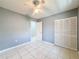 Bedroom features include tile flooring, light gray walls and a ceiling fan. Closet also featured at 5147 Larch Ln, New Port Richey, FL 34653