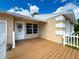 Inviting front porch with wood flooring, white picket fence, and neutral exterior with decorative trim at 5147 Larch Ln, New Port Richey, FL 34653