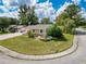 Charming home with manicured lawn, mature trees, and decorative water feature in front yard at 5147 Larch Ln, New Port Richey, FL 34653