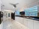 Bright kitchen with white cabinetry, dark countertops, stainless steel appliances, and tile flooring at 5147 Larch Ln, New Port Richey, FL 34653