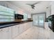 Kitchen with white cabinets, a black microwave, and granite countertops with double doors leading outside at 5147 Larch Ln, New Port Richey, FL 34653
