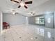 Open living room with tile floors, multiple ceiling fans, and a front door view at 5147 Larch Ln, New Port Richey, FL 34653