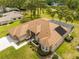 Sprawling property highlighting verdant lawns, a screened pool, and a brick paver driveway and walkway at 5164 Golf Club Ln, Spring Hill, FL 34609