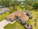 Expansive home showcasing lush landscaping, a screened pool, and a brick paver driveway and entryway at 5164 Golf Club Ln, Spring Hill, FL 34609