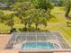 Aerial view of a pool and spa with screened enclosure in a well-maintained backyard at 5164 Golf Club Ln, Spring Hill, FL 34609