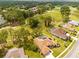 A lovely aerial view of a home with a golf course view, mature trees, and a screened pool at 5164 Golf Club Ln, Spring Hill, FL 34609