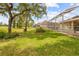 Beautiful backyard featuring a manicured lawn with a screened-in pool at 5164 Golf Club Ln, Spring Hill, FL 34609