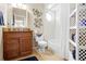 Well-lit bathroom with a wood vanity, granite countertop, a decorative mirror, and a shower-tub combo at 5164 Golf Club Ln, Spring Hill, FL 34609