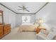 Bright bedroom featuring a ceiling fan, a large window, and closet storage at 5164 Golf Club Ln, Spring Hill, FL 34609