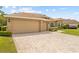 Charming home featuring a three-car garage, brick accents, manicured lawn, and a brick driveway at 5164 Golf Club Ln, Spring Hill, FL 34609