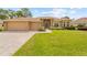 Charming home with manicured lawn, brick accents, a brick paver driveway, and a two-car garage at 5164 Golf Club Ln, Spring Hill, FL 34609