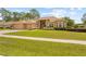 Attractive home with a three-car garage, beautiful landscaping, and a well-manicured lawn at 5164 Golf Club Ln, Spring Hill, FL 34609