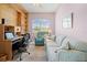 Bright home office featuring built-in shelves, a comfortable seating area, and ample desk space at 5164 Golf Club Ln, Spring Hill, FL 34609