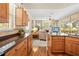 Open-concept kitchen with granite countertops, wood cabinetry, and stainless steel appliances at 5164 Golf Club Ln, Spring Hill, FL 34609