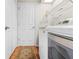 Functional laundry room with a modern washer and dryer, shelving, and wood-look flooring at 5164 Golf Club Ln, Spring Hill, FL 34609