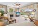 Bright living room with fireplace, ceiling fan, and sliding glass doors to screened pool at 5164 Golf Club Ln, Spring Hill, FL 34609
