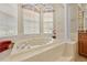 Garden tub in bathroom with chandelier and natural light at 5164 Golf Club Ln, Spring Hill, FL 34609