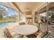 Screened patio with a table and chairs overlooking the pool and golf course at 5164 Golf Club Ln, Spring Hill, FL 34609