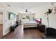 Comfortable bedroom featuring hardwood floor, ceiling fan, television, and natural light from the window at 5341 Birchwood Rd, Spring Hill, FL 34608
