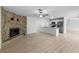 Spacious living area with wood floors, a stone fireplace, and access to the kitchen at 5378 Mosquero Rd, Spring Hill, FL 34606