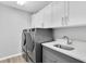 Clean and modern laundry room with new washer, dryer, white cabinets and a sink at 5638 Hereford Dr, New Port Richey, FL 34655
