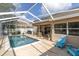 Relaxing screened-in pool area with clear water, stylish patio furniture, and ample space for outdoor enjoyment at 5638 Hereford Dr, New Port Richey, FL 34655