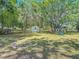 A spacious backyard featuring mature trees, an in-ground fire pit and a playground set at 6203 Sumter Dr, Brooksville, FL 34602