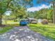Outdoor space featuring a long driveway leading to a house, offering ample parking for vehicles and trailers at 6203 Sumter Dr, Brooksville, FL 34602