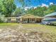 Inviting single-story home featuring a cozy front porch, a well-manicured lawn, and a boat in the drive at 6203 Sumter Dr, Brooksville, FL 34602