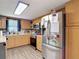Functional kitchen featuring stainless steel appliances, wood cabinetry, and laminate flooring at 6203 Sumter Dr, Brooksville, FL 34602