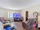 The living room has wood-look floors, neutral paint, and a modern television at 6203 Sumter Dr, Brooksville, FL 34602