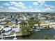 An aerial view shows a canal-lined neighborhood featuring many waterfront homes under a bright blue sky with scattered clouds at 6521 Boatyard Dr, Hudson, FL 34667