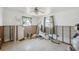 A bedroom needing renovation is shown, with visible wall framing, a ceiling fan, and natural light from two small windows at 6521 Boatyard Dr, Hudson, FL 34667