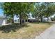 Charming single-story home with a brick facade, screened in porch, mature trees, and waterfront canal at 6521 Boatyard Dr, Hudson, FL 34667
