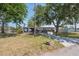 Charming single-story home with a brick facade, screened in porch, and a spacious front yard with mature trees at 6521 Boatyard Dr, Hudson, FL 34667