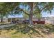 Charming single-story home with a brick facade, screened in porch, and a spacious front yard with a large tree at 6521 Boatyard Dr, Hudson, FL 34667