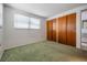 Bedroom with carpet flooring, a window and a closet with doors at 6611 Ridge Crest Dr, Port Richey, FL 34668