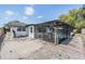 Backyard screened-in pool area, with a white fence and gravel, offers a private oasis for relaxation and outdoor enjoyment at 6611 Ridge Crest Dr, Port Richey, FL 34668